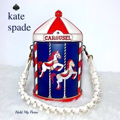 Kate Spade Winter Wonders 3D Carousel Painted Horses Merry-Go-Round Crossbody Bag Gorgeous Handbag!  Adorned with 6 White & Gray Horses NWT MSRP $449.00 Colors: Navy Blue, Red, White Gold tone hardware  Detachable Adjustable Crossbody Strap Drop: 22" Plus an exclusive added bonus detachable White Braided Handle Strap to wear it as a handbag! So versatile!  ksny foil embossed logo Magnetic snap closure Dust Bag Not Included Smooth Leather Lining: Two Way Script Logo Lining Measures approximately: 3d Carousel, Gray Horses, Kate Spade Store, Painted Horses, Keychain Charms, Kate Spade Crossbody Purse, Bag Keychain, Disney Bag, Merry Go Round