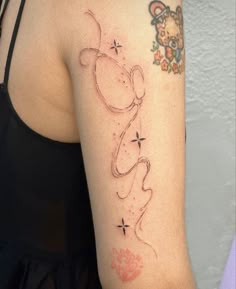 a woman's arm with a tattoo on it that has a teddy bear and stars