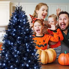 a family celebrating halloween with a tree and decorations