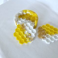 two pieces of yellow and white honeycombs sitting on top of a white sheet