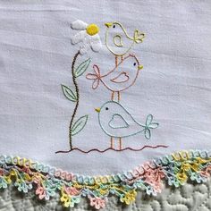 a close up of a piece of cloth with embroidered flowers and birds on the side