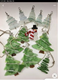 a collection of sea glass christmas trees and snowmen with beaded necklaces on them