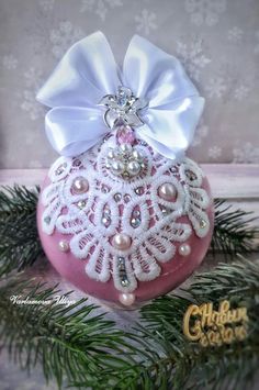 a pink ornament with a white bow on it