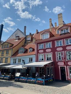 the buildings are painted red and yellow with many windows on each side, along with white awnings