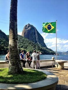 some people are standing by the water with a flag