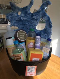 a basket filled with lots of different types of soaps and lotions on top of a wooden table