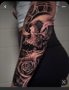 a person with a skull and rose tattoo on their arm