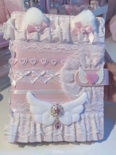 a pink and white box with angel wings on it