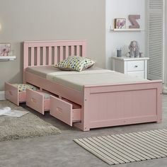 a pink bed with drawers underneath it in a child's bedroom setting, on carpeted flooring