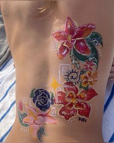 the back of a woman's body with flowers painted on her stomach and chest