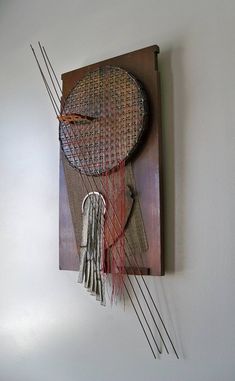 a wall hanging made out of wood and string