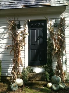 a white house with pumpkins and gourds in front