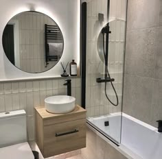 a bathroom with a sink, toilet and bathtub next to a mirror on the wall