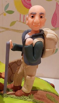 a figurine is posed on top of a cake