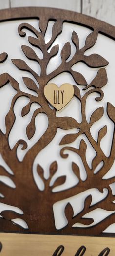 a wooden sign that says lily with a heart in the tree on it's side