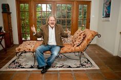 a man sitting on top of a couch in a living room