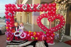 a valentine's day display with balloons and decorations in the shape of heart shaped letters