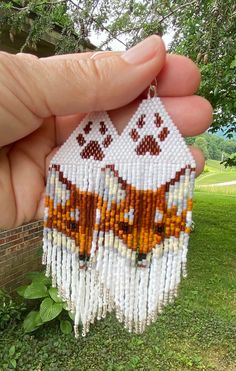 a hand holding a small beaded house ornament in it's palm