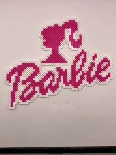 the word peopie is made out of pink and white beads on a refrigerator