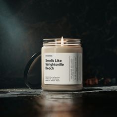 a candle that says i hate everyone except us 3 in front of a dark background