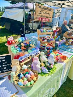 there are many stuffed animals on display at this outdoor vendor's market stall that sells them