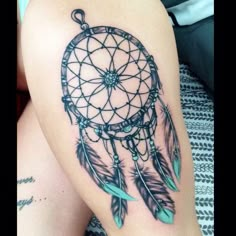 the back of a woman's shoulder with a dream catcher tattoo design on it