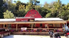 a red barn with flowers and motorcycles parked in front