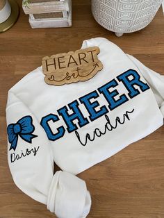 ** Please read before buying **  Personalized Embroidered CHEER leader sweatshirt with glitter HTV applique. Fit: Unisex, Fits loose/relaxed Sizing: S,M,L,XL,2XL Material: 50% Cotton, 50% Polyester Embroidery Details: "CHEER leader" centered across the chest Bow and name on right shoulder sleeve PROCESSING/TURNAROUND TIME: -Processing/Turn around times may vary. Please check the estimated ship/delivery times. -Processing/Turn around time DOES NOT include shipping time. Cheerleading Tshirts Designs Ideas, High School Cheer Sweatshirts Design, Nationals Cheer Shirts, Competitive Cheer Shirts, Cheer Embroidery Design, Varsity Cotton Sweatshirt For Cheerleading, Varsity Long Sleeve Sweatshirt For Cheerleading, Cheer Gifts Ideas, Cheer Stuff Ideas