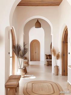 an arched hallway with wooden benches and potted plants on either side of the doorway