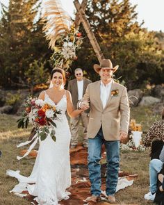 a bride and groom walking down the aisle at their outdoor wedding ceremony in an open field