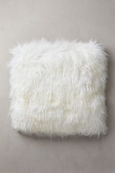 a white fluffy pillow sitting on top of a table