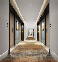 an empty hallway with two doors leading to another room and carpeted flooring on both sides