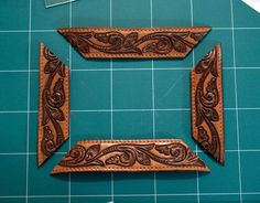 two pieces of leather sitting on top of a cutting board