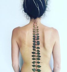 the back of a woman's neck with leaves on it