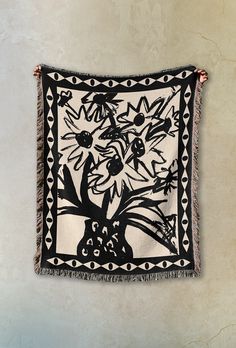 a black and white tapestry hanging on the wall