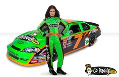 a woman standing next to a green and orange car