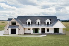 a large white house sitting on top of a lush green field