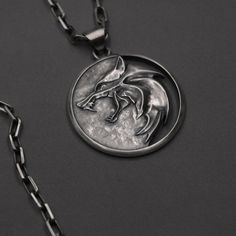 Silver Witcher Medallion: Embrace the Path of the Witcher Step into the world of magic, monsters, and mystery with the Silver Witcher Medallion, a meticulously crafted piece that embodies the spirit of the Witcher saga. This iconic medallion, shaped in the likeness of a wolf's head, is not just a symbol of the Witcher's profession but also a powerful emblem of intuition, strength, and the solitary path walked by these monster hunters. Ideal for fans of the series, cosplayers, or anyone drawn to Witcher Pendant, The Witcher Medallion, Witcher Necklace, Witcher Medallion, The Witcher Series, Witcher Series, Fandom Jewelry, Dark Creatures, Attractive Eyes