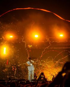 a man standing on top of a stage holding a microphone in front of an audience