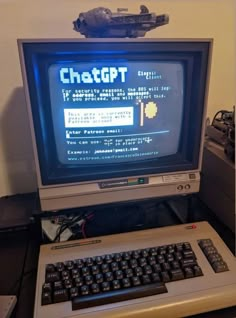 an old computer sitting on top of a desk next to a keyboard and monitor screen