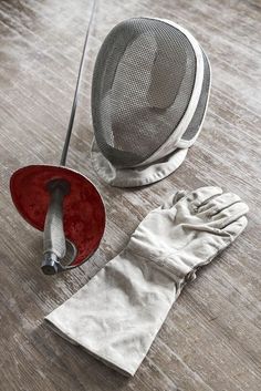 a pair of white gloves sitting on top of a wooden floor next to a red duster