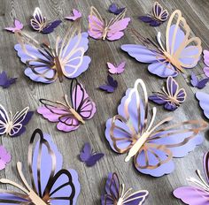 purple and gold paper butterflies on wooden floor