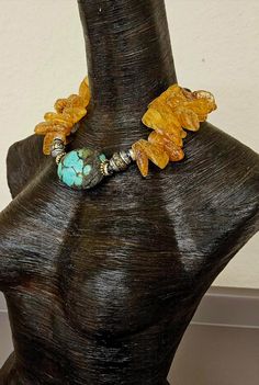 A luxury statement necklace for the most glamorous and discerning of buyers. A huge Hubei Turquoise Boulder (2.5" x 2) is the focal point, flanked by gold tone daisy metal spacers, gold aurora borealis rhinestone rondelles and mixed metal handcrafted Tibetan repousse beads. Honey colored Mexican Amber gemstones form the bulk of the necklace, while the back is finished with more rhinestone rondelles, turquoise stones, and shiny metal spacers. This closes with a gold tone leaf and vine motif clasp Rocker Chic Accessories, Hubei Turquoise, Unique Pendant Necklace, Amber Gemstone, Statement Bib Necklace, Chest Piece, Mermaid Necklace, Honey Colour, Turquoise Stones