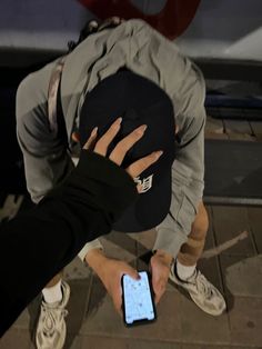 a person holding a cell phone in their hand and touching the screen with both hands