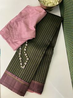 Presenting a Tejasvi in a rich earthy green pure handwoven kanchipuram silk that packs such grandeur in its intricate threadwoven body. The dusty pink border and pallu add a lovely juxtaposition of modern elegance while keeping the richness intact with the pure zari woven through it all. Green Silk Saree Contrast Blouse, Silk Saree Contrast Blouse, Silk Saree Blouse Design, Saree Contrast Blouse, Pink Silk Saree, Green Silk Saree, Office Outfits Women Casual, Kanchi Sarees, Teacup Crafts