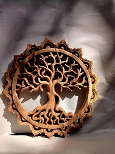 a carved wooden tree of life symbol on a white background