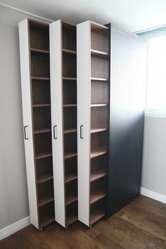 an empty room with two tall bookshelves next to each other