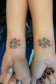 two people with matching tattoos on their arms holding each other's hands and one has a puzzle piece tattooed on the wrist