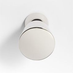 a white wall mounted light with two round lights on it's sides and one circular light fixture in the middle