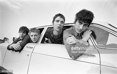 three young men sitting in the back of a car with their arms crossed and looking out